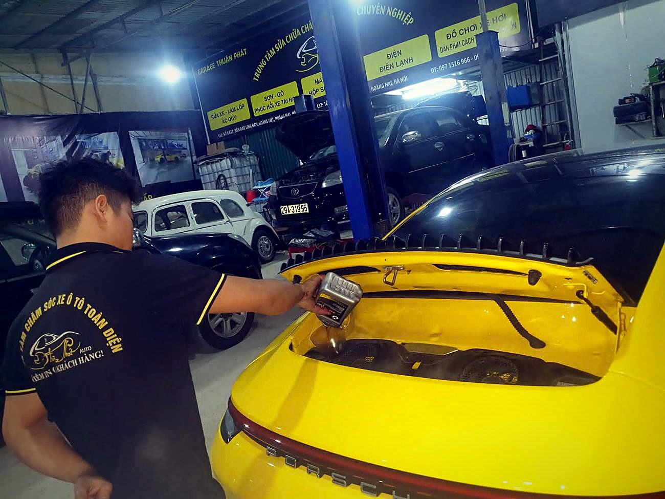 Kỹ thuật viên làm việc trên xe thể thao màu vàng